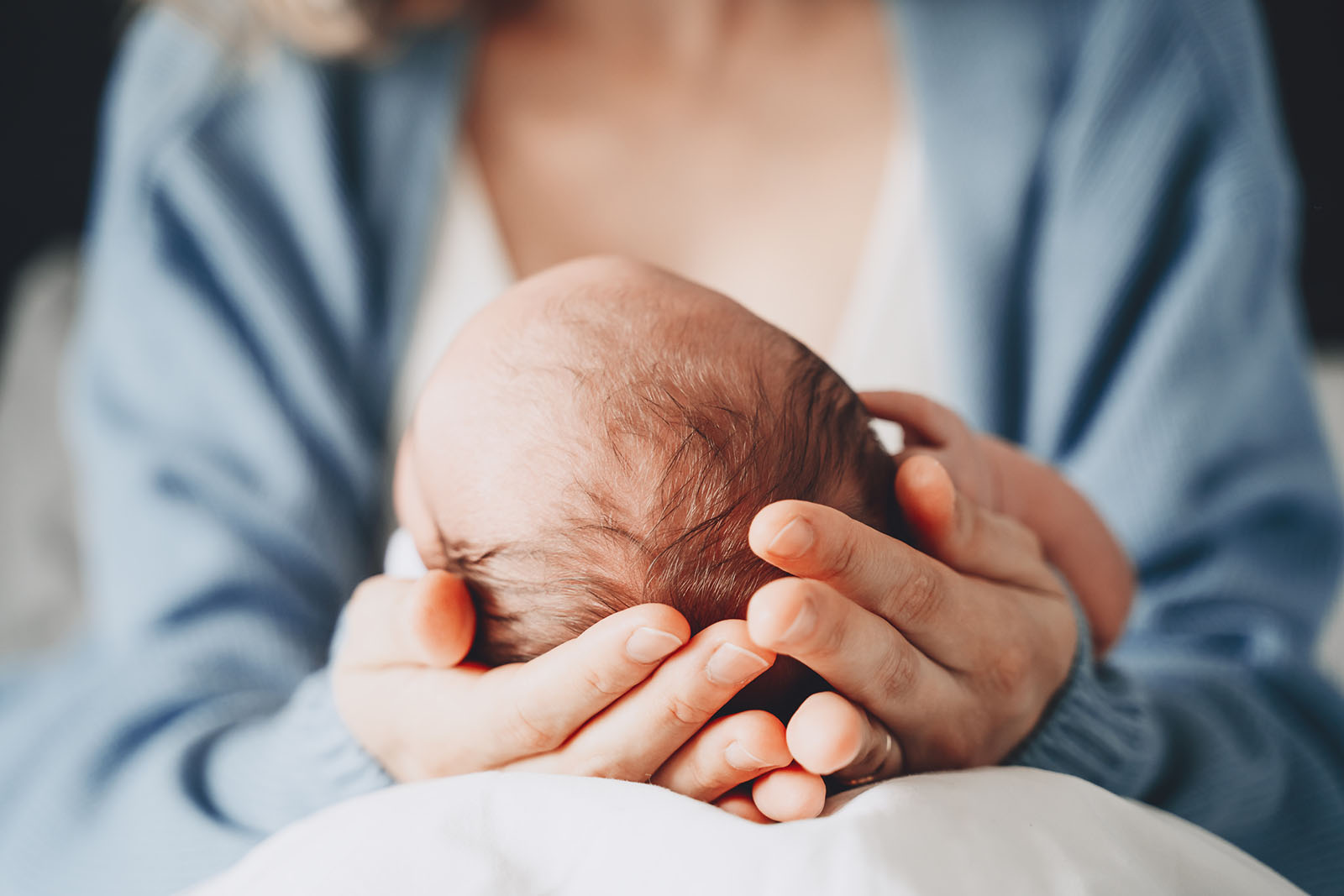 Newborn in hands - Nannies by Noa - New York & Tri-State Area Nanny Agency - Newborn Care - Nannying Jobs Near Me
